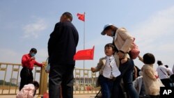 Un niño sostiene una bandera nacional china durante una visita a la Plaza de Tiananmen para las vacaciones del Primero de Mayo en Beijing el lunes 3 de mayo de 2021