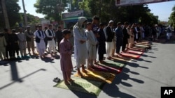 Men attend the Eid al-Fitr prayers outside a mosque in Kabul, Afghanistan, Sunday, May 24, 2020. The Taliban and Afghanistan's president announced late Saturday a three-day cease-fire ahead of a major Islamic holiday that begins Sunday to mark the…