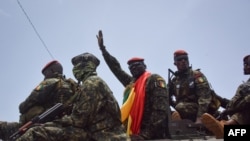 Le lieutenant-colonel Mamady Doumbouya (C), chef des forces spéciales de l'armée et chef du coup d'État, salue la foule à son arrivée au Palais du Peuple à Conakry le 6 septembre 2021.