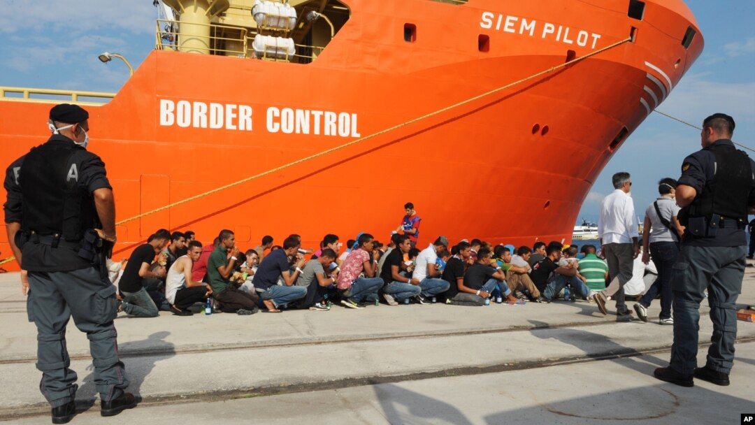 Rescued migrants line up after disembarking from the Norwegian cargo ship Siem Pilot at the Reggio Calabria's harbor, Italy, Aug. 8, 2015. 