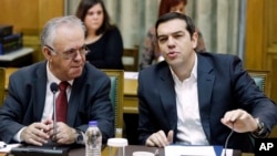 Greece's Prime Minister Alexis Tsipras, right, speaks during a cabinet meeting as Deputy Prime Minister Yannis Dragasakis listens to him in Athens, Nov. 10, 2015. 