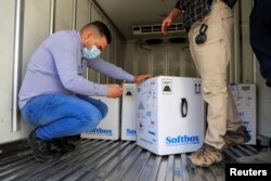 FILE - Personnel check the first shipment of the Pfizer's vaccine against the coronavirus disease (COVID-19) at Baghdad International Airport, in Baghdad, Iraq, Apr. 11, 2021.