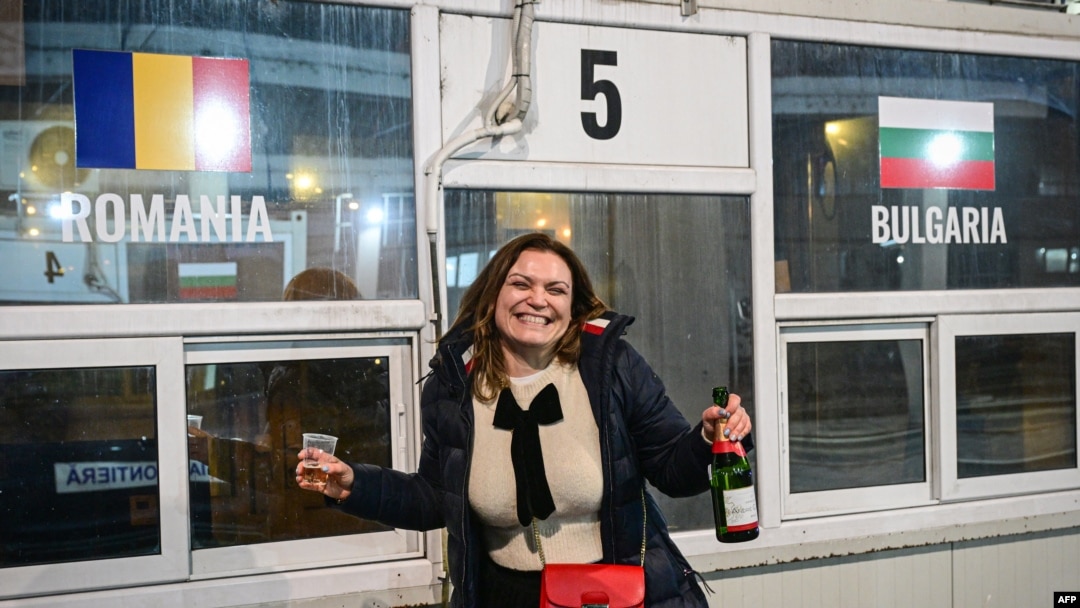 Seorang perempuan Bulgaria merayakan masuknya Bulgaria dan Romania ke zona Schengen di posko perbatasan Giurgiu-Ruse antara Romania dan Bulgaria, 1 Januari 2025. (Foto: Daniel Mihailescu/AFP)