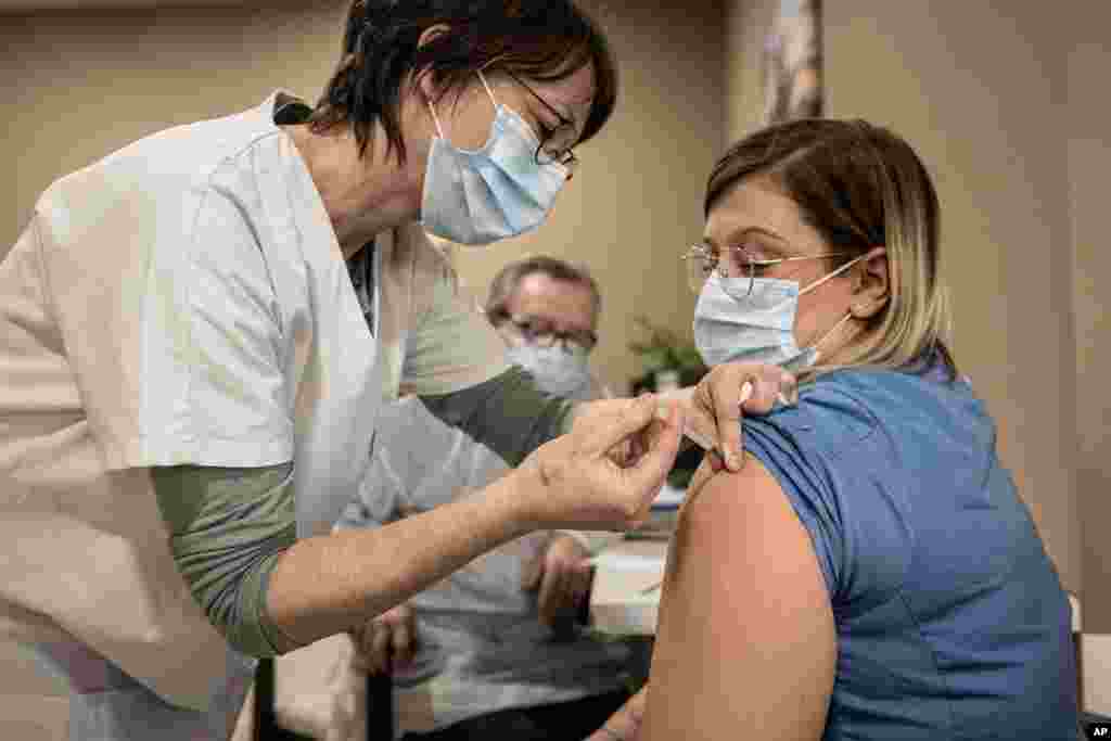 واکسیناسیون در اغلب کشورهای جهان آغاز شده است. در این عکس ، یک زن پرستار در شهر لیژ کشور بلژیک واکسن فایزر را دریافت می‌کند. 