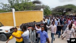 Mourners carry the body of the Chairwoman of the Shangani district, who was killed during an attack on Wednesday, in Mogadishu, Somalia, Thursday, July 25, 2019. 