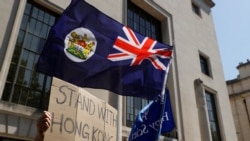 FILE - A flag of Hong Kong is waved in front of a placard during a protest against Hong Kong's deteriorating freedoms, outside China's embassy, in London, Britain, July 31, 2020.