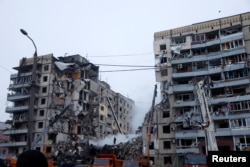 Emergency personnel work at the site where an apartment block was heavily damaged by a Russian missile strike, amid Russia's attack on Ukraine, in Dnipro, Ukraine, Jan. 15, 2023.