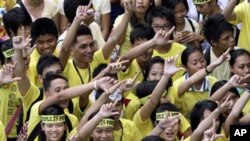 Students flash the 'L' sign for Laban or Fight as they join the march celebrating the 25th anniversary of People Power revolution, February 25, 2011 in suburban Pasig City east of Manila, Philippines