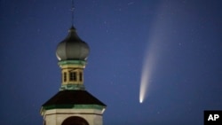 The comet Neowise or C/2020 F3 is seen behind an Orthodox church over the Turets, Belarus, 110 kilometers (69 miles) west of capital Minsk, early Tuesday, July 14, 2020. (AP Photo/Sergei Grits)