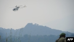 Un hélicoptère des Nations Unies survole des soldats des Forces armées de la République démocratique du Congo à environ 20 km de la ville de Goma, 11 juillet 2012.