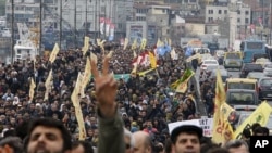 Demonstrators march with yellow Peace and Democracy Party (BDP) flags and display outlawed Kurdistan Workers Party (PKK) banners during a protest against the High Election Board's decision in Istanbul, April 19, 2011