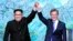 North Korean leader Kim Jong Un, left, and South Korean President Moon Jae-in raise their hands after signing a joint statement at the border village of Panmunjom in the Demilitarized Zone, South Korea, April 27, 2018.