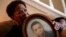 In this Aug. 9, 2018 photo, Eberlene King poses with a photograph of her brother William Roy Prather when he was about 15 years old at her home in Doraville, Georgia.