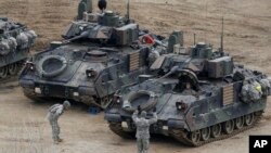 A U.S. Army soldier gestures to a fellow solider as they participate in annual military drills in Yeoncheon, South Korea, near the border with North Korea, April 11, 2013. 