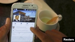 A person uses a smartphone to look at the Facebook page of Cambodia's Prime Minister Hun Sen in central Phnom Penh, Cambodia October 7, 2015. 