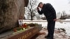 A man bows after leaving flowers at a monument to the victims of political repression in memory of late opposition leader Boris Nemtsov in Saint Petersburg, Russia, on the 10th anniversary of Nemtsov's assassination, Feb. 27, 2025.