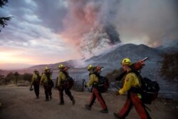 FILE - Firefighters walk in line during a wildfire in Yucaipa, Calif., Sept. 5, 2020. Three wildfires sent people fleeing, with one trapping campers in the Sierra National Forest, as a heat wave pushed temperatures into triple digits.