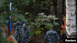 FILE - Law enforcement officers guard an area near the grave of Russian mercenary chief Yevgeny Prigozhin, who was killed in a plane crash last week, at the Porokhovskoye cemetery in Saint Petersburg, Russia August 29, 2023. 