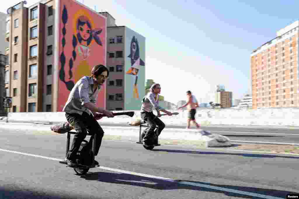 Vinicius Sanctus and Alessandro Russo ride electric monowheels called &#39;nuvem&#39; (cloud) in Sao Paulo, Brazil. Their invention was inspired by the magic flying brooms of the Harry Potter series.