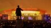 People watch a light show at the new soccer stadium on Krestovsky Island, which will host some 2018 World Cup and 2017 Confederations Cup matches, in St. Petersburg, Russia, April 22, 2017. A statue of Sergei Kirov, an early Bolshevik leader, is in the fo