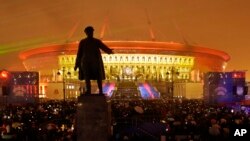 People watch a light show at the new soccer stadium on Krestovsky Island, which will host some 2018 World Cup and 2017 Confederations Cup matches, in St. Petersburg, Russia, April 22, 2017. A statue of Sergei Kirov, an early Bolshevik leader, is in the fo