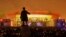People watch a light show at the new soccer stadium on Krestovsky Island, which will host some 2018 World Cup and 2017 Confederations Cup matches, in St. Petersburg, Russia, April 22, 2017. A statue of Sergei Kirov, an early Bolshevik leader, is in the fo