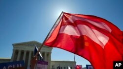 Equality flag waves during demonstrations in front of the Supreme Court, Washington, April 28, 2015. 