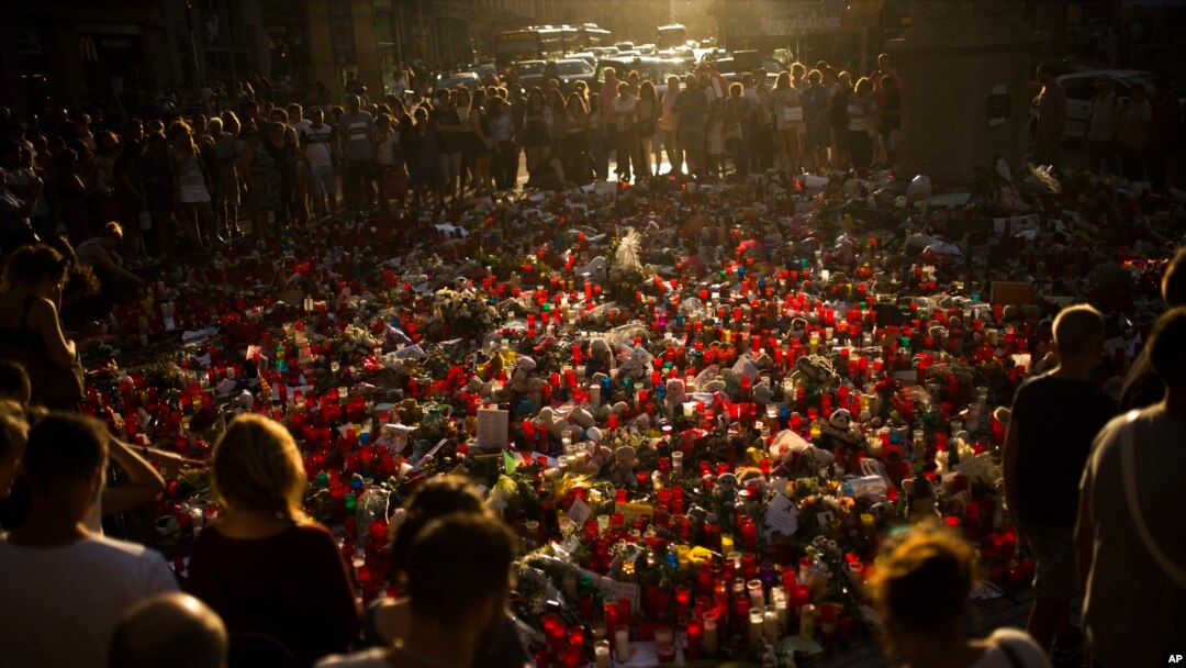 Masyarakat berdiri dekat lilin-lilin dan bunga-bunga yang diletakkan di tanah untuk menghormati korban serangan teroris yang membunuh dan melukai banyak orang di Barcelona, Spanyol, 24 Agustus 2017. 