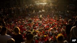 Masyarakat berdiri dekat lilin-lilin dan bunga-bunga yang diletakkan di tanah untuk menghormati korban serangan teroris yang membunuh dan melukai banyak orang di Barcelona, Spanyol, 24 Agustus 2017. 