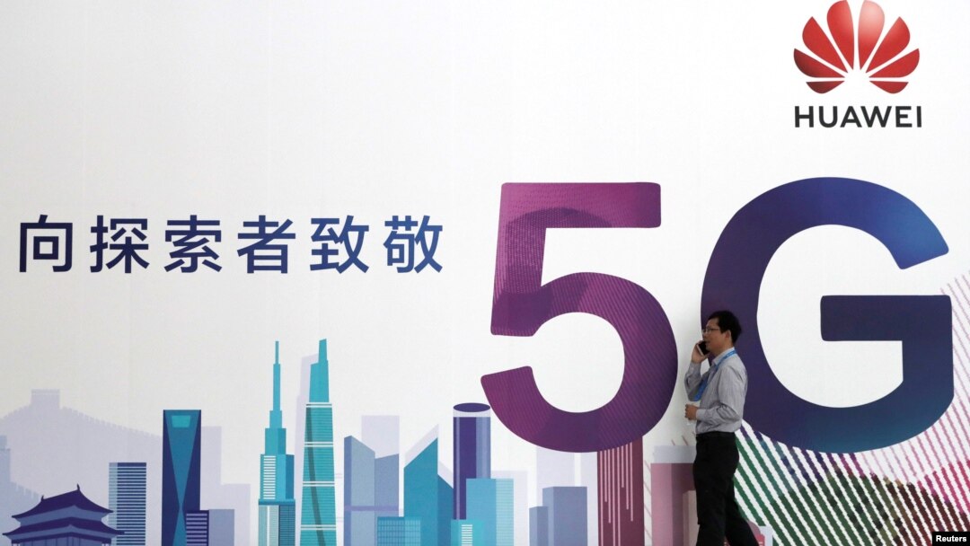 一名男子走过在北京举办的中国国际信息通信展览会的一块华为公司5G技术广告牌。（2018年9月26日）