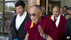 Tibetan spiritual leader the Dalai Lama, center, gestures after being received by the newly-elected Prime Minister of the Tibetan government-in-exile, Lobsang Sangay, left, as he arrives at the Kangra airport near Dharmsala, India, Sunday, Nov. 13, 2011.