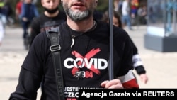 People take part in a protest against coronavirus restrictions, in Krakow, Poland, April 11, 2021. The writing on the shirt reads: "I'm a free man." (Jakub Pokrzycki/Agencja Gazeta via Reuters)