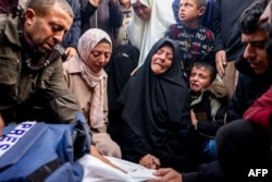 Family and relatives mourn over the body of Palestinian journalist Ahmed Al-Shayah, covered with a press vest, after he was killed during an Israeli strike the previous night in Khan Yunis, at Nasser Hospital, in the southern Gaza Strip, Jan. 16, 2025.