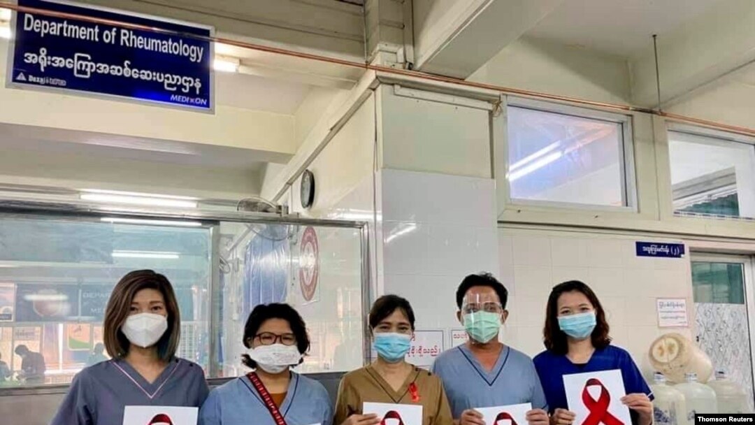 미얀마 병원 의료진이 3일 파업을 선언한 가운데 저항의 상징으로 빨간색 리본 그림을 들고 있다. 