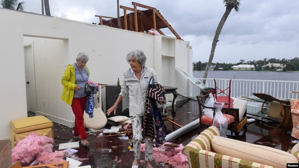 A Bayou West resident and friend try to salvage items from her home after an apparent tornado touched down on the central beach community after Hurricane Milton in Vero Beach, Fla., Oct.11, 2024. (Kaila Jones/USA Today Network via Reuters)