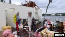 A Bayou West resident and friend try to salvage items from her home after an apparent tornado touched down on the central beach community after Hurricane Milton in Vero Beach, Fla., Oct.11, 2024. (Kaila Jones/USA Today Network via Reuters)