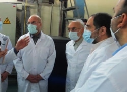 FILE - A photo provided by Iran's Atomic Energy Organization shows Iranian Parliament speaker Mohammad Bagher Ghalibaf, left, and head of the Iranian Atomic Organization Ali Akbar Salehi, right, at Fordo Uranium Conversion Facility, Jan. 28, 2021.