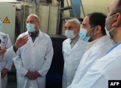 FILE - A photo provided by Iran's Atomic Energy Organization shows Iranian Parliament speaker Mohammad Bagher Ghalibaf, left, and head of the Iranian Atomic Organization Ali Akbar Salehi, right, at Fordo Uranium Conversion Facility, Jan. 28, 2021.