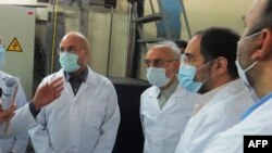 FILE - A picture provided by Iran's Atomic Energy Organization shows Iranian Parliament speaker Mohammad Bagher Ghalibaf, left, and head of the Iranian Atomic Organization Ali Akbar Salehi, right, at the Fordo Uranium Conversion Facility, Jan. 28, 2021.