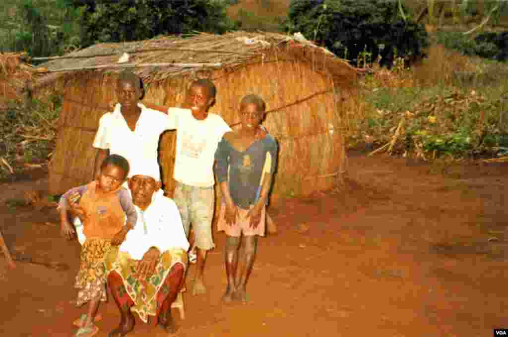 Salayi Mzembe and her grandchildren in front of their home, get their news from VOA.