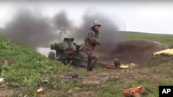 An Armenian serviceman fires a cannon toward Azerbaijan positions at the contact line of the self-proclaimed Republic of Nagorno-Karabakh, Azerbaijan, in this image taken from a video released by Armenian Defense Ministry on Oct. 2, 2020.