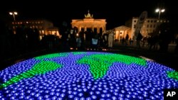 Активісти Всесвітнього фонду дикої природи підсвітили глобус світлодіодними вогнями, щоб відзначити Годину Землі, біля Бранденбурзьких воріт в Берліні 25 березня 2017 року.