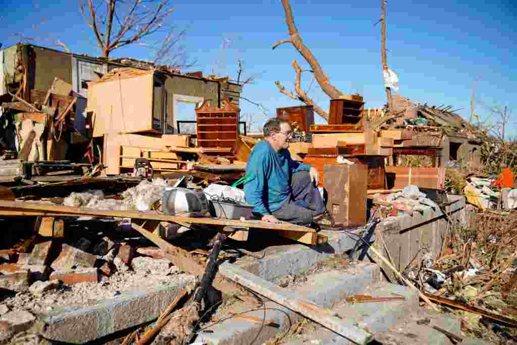 Rick Foley, de 70 años, se sienta afuera de su casa después del devastador brote de tornados en Mayfield, Kentucky. Rick sobrevivió a la tormenta agachado bajo una puerta dentro de su casa.