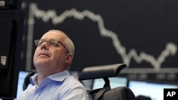 A stock trader watches his screens at the German stock exchange in Frankfurt, Germany, September 23, 2011.