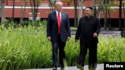 Presiden AS Donald Trump dan pemimpin Korea Utara Kim Jong Un dalam pertemuan di Singapura, 12 Juni 2018 (foto: dok). 