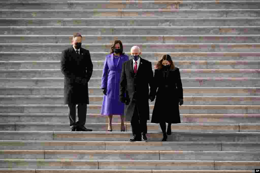 Vice President Kamala Harris and her husband Doug Emhoffl watch as former Vice President Mike Pence and his wife Karen Pence depart the Capitol after the inauguration ceremony for herself and President Joe Biden, at the Capitol in Washington.