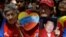 A woman holds a picture of Venezuela's President Hugo Chavez as supporters gather at Simon Bolivar square in Caracas,Venezuela, Dec. 9, 2012.