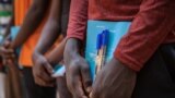 FILE - Newly released child soldiers receive school supplies as part of a reintegration kit which includes clothing and mosquito nets during a release ceremony for child soldiers in Yambio, South Sudan, on Feb. 7, 2018.