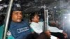 FILE - Mohammad Kamaruzzaman, center, assistant secretary general of the Jamaat-e-Islami party, sits inside a police van. 