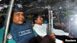 FILE - Mohammad Kamaruzzaman, center, assistant secretary general of the Jamaat-e-Islami party, sits inside a police van. 